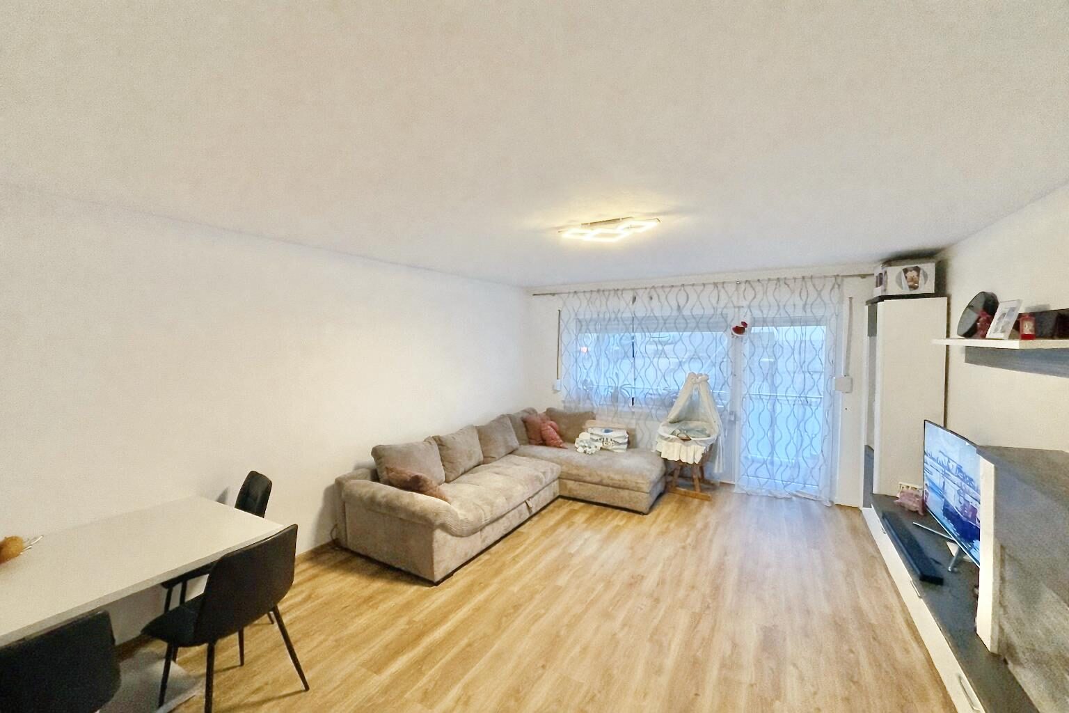 Wohnbereich der kernsanierten Erdgeschosswohnung mit Zugang zum Balkon